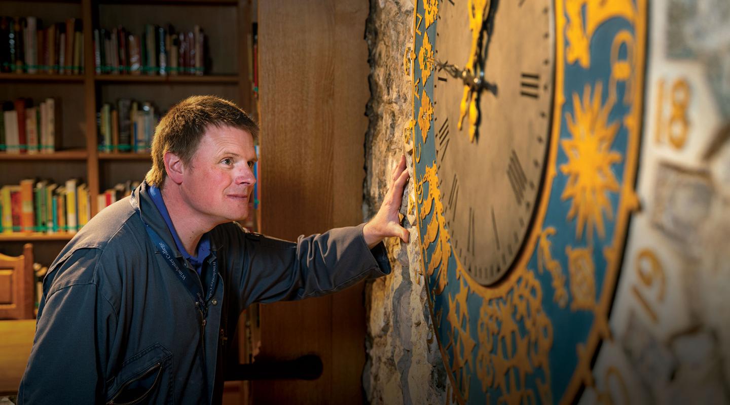 Man looking at antique clock on wall