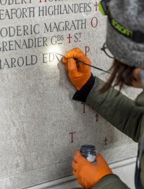 Woman painting inscriptions on building 