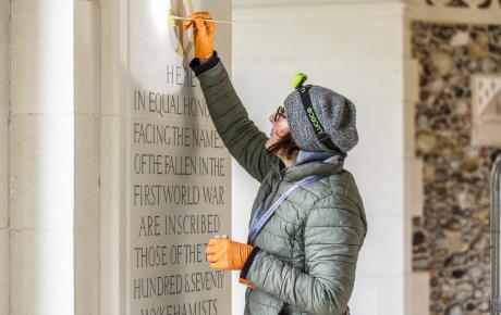 Woman painting inscriptions on building 