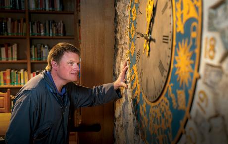 Man looking at antique clock on wall