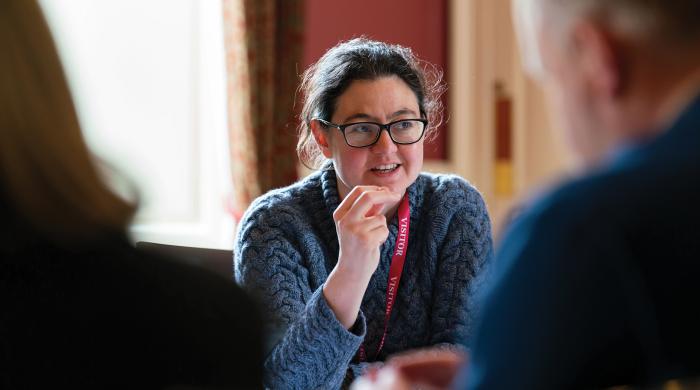 Lady discussing with colleagues around a table