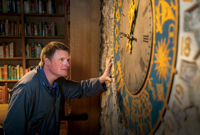 Man looking at antique clock on wall